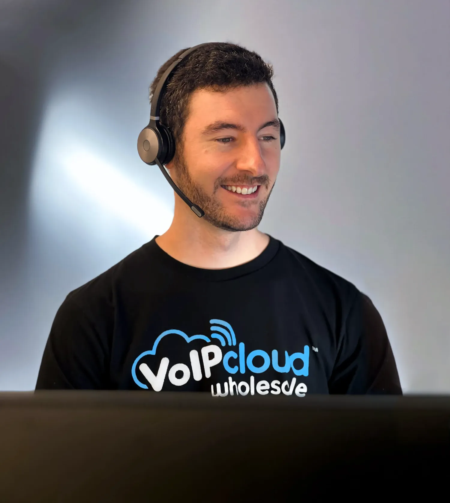 VoIPline support team member wearing a headset at a laptop
